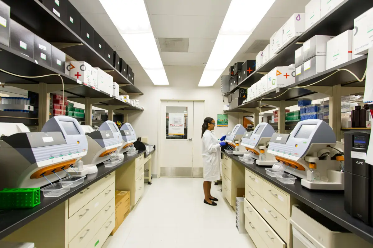 Laboratory technician working near high-throughput diagnostic testing equipment